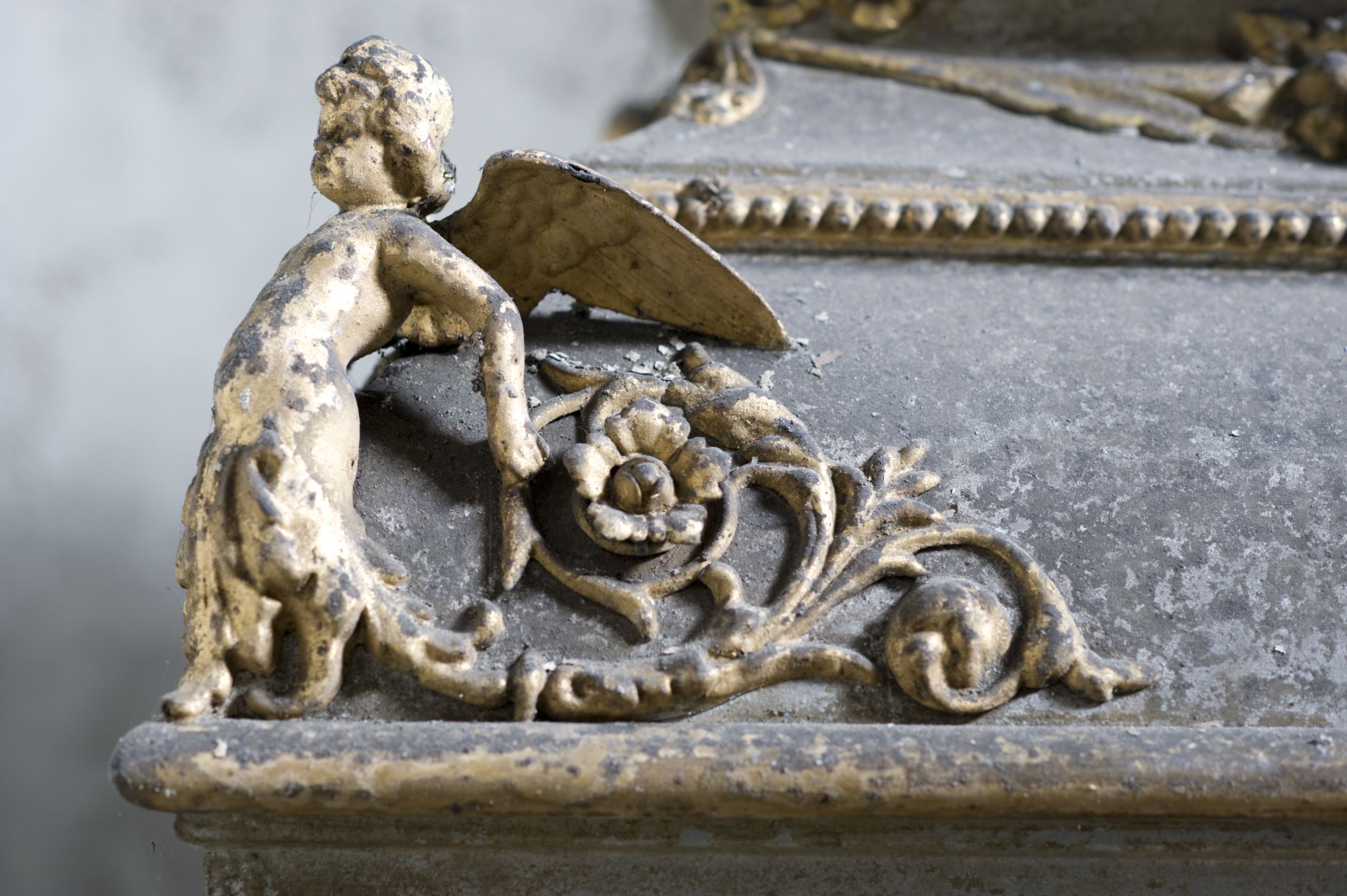 A golden cherub on the corner of the coffin