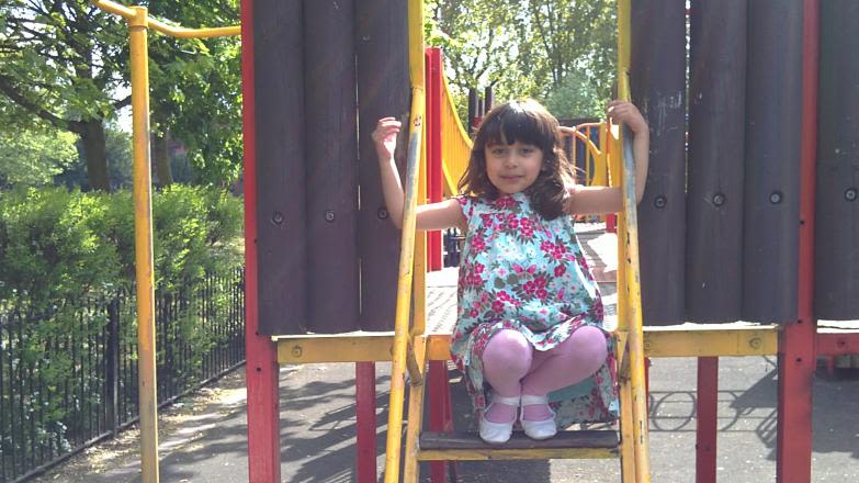 Aamina Khan sat on an outdoor park playground.