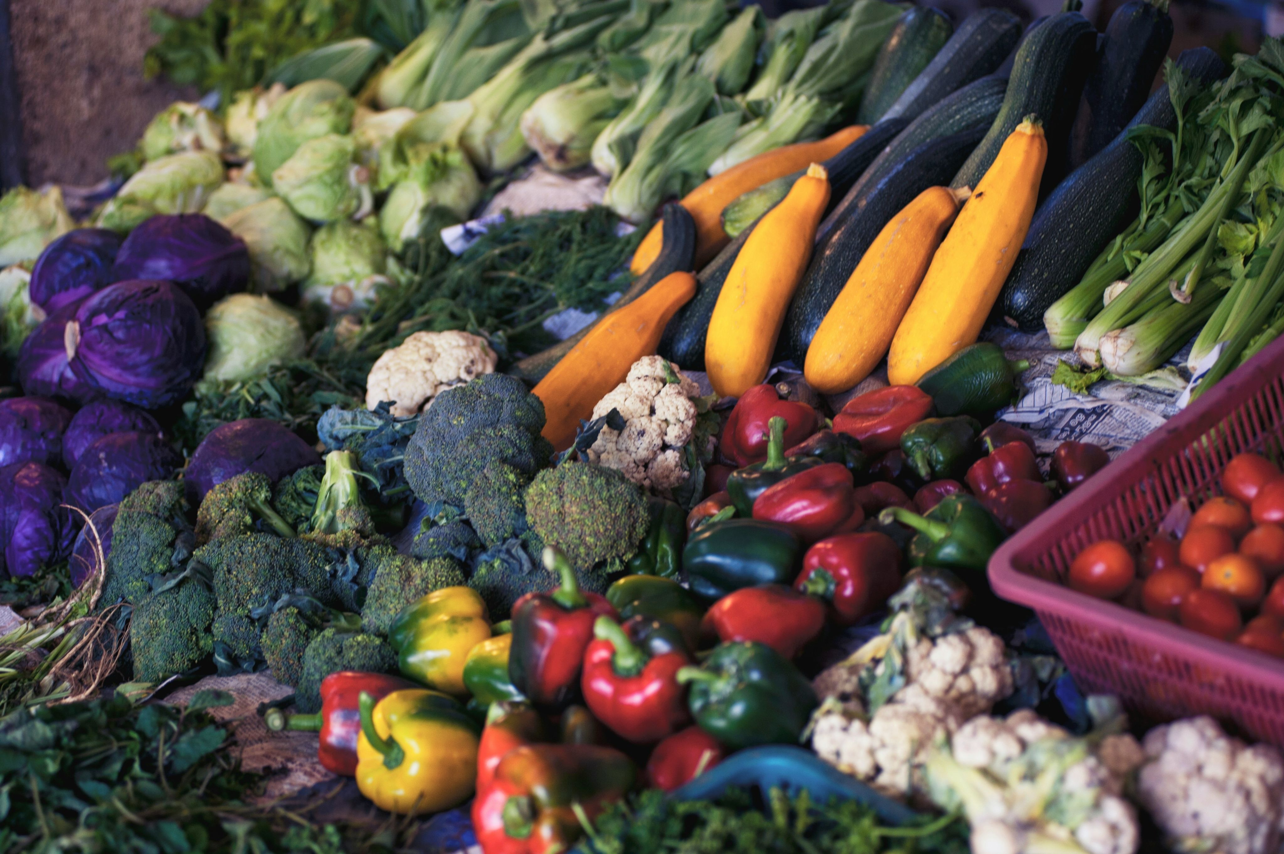 Lots of different vegetables: broccolis, cauliflowers, yellow courgettes, red and green peppers 