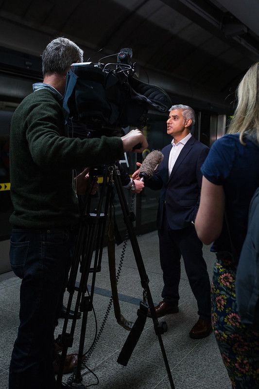 London mayor Sadiq Khan answers questions from reporters while being filmed.