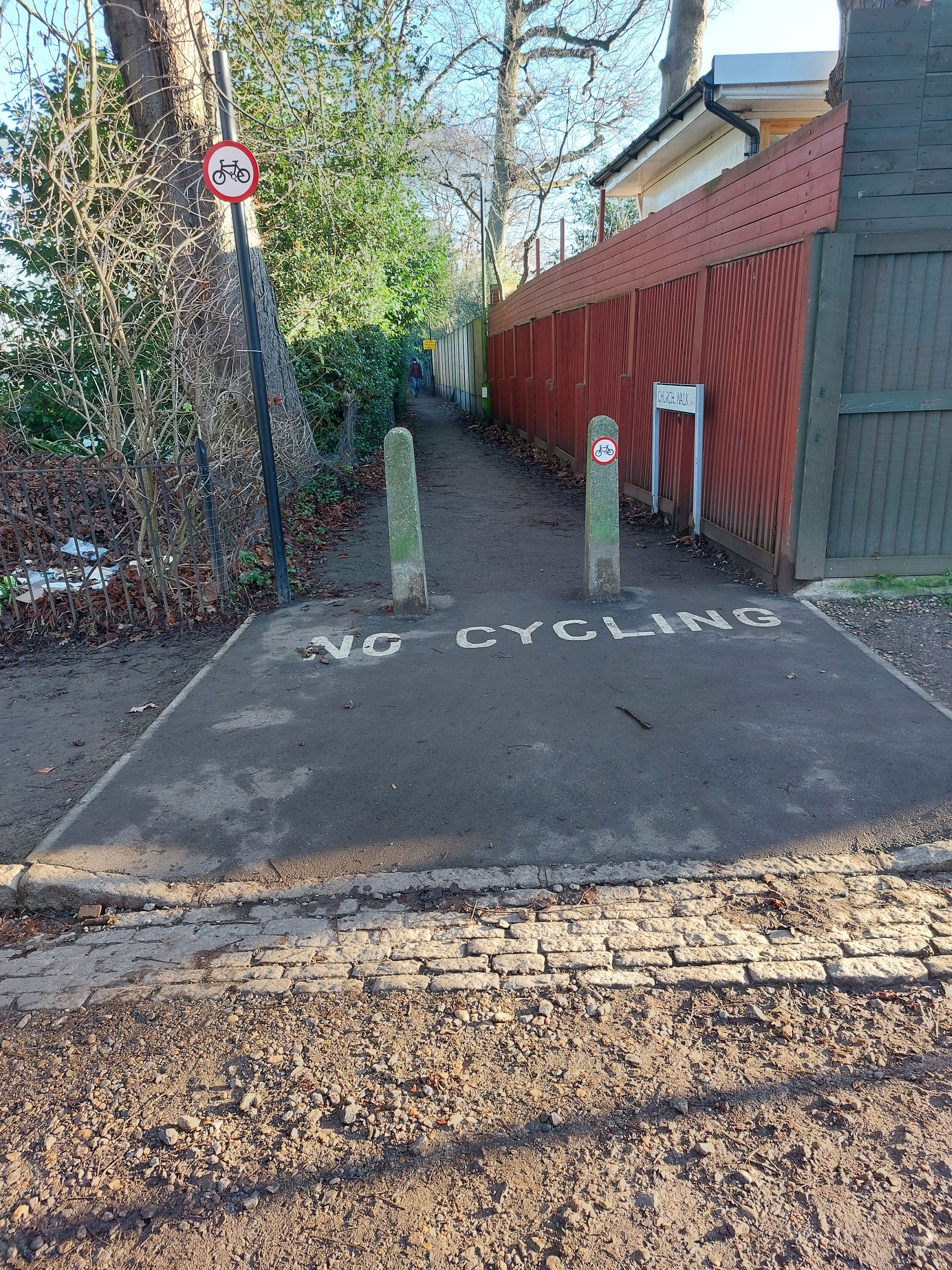 Entry into an alleyway with "No cycling" painted on the tarmac.