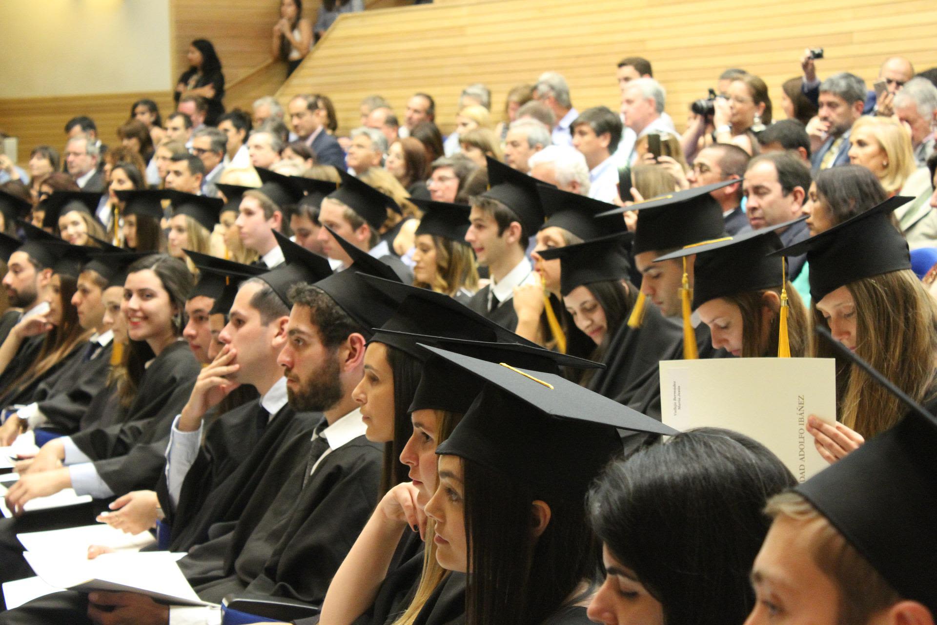 University students in graduation dress sitting in a lecture hall