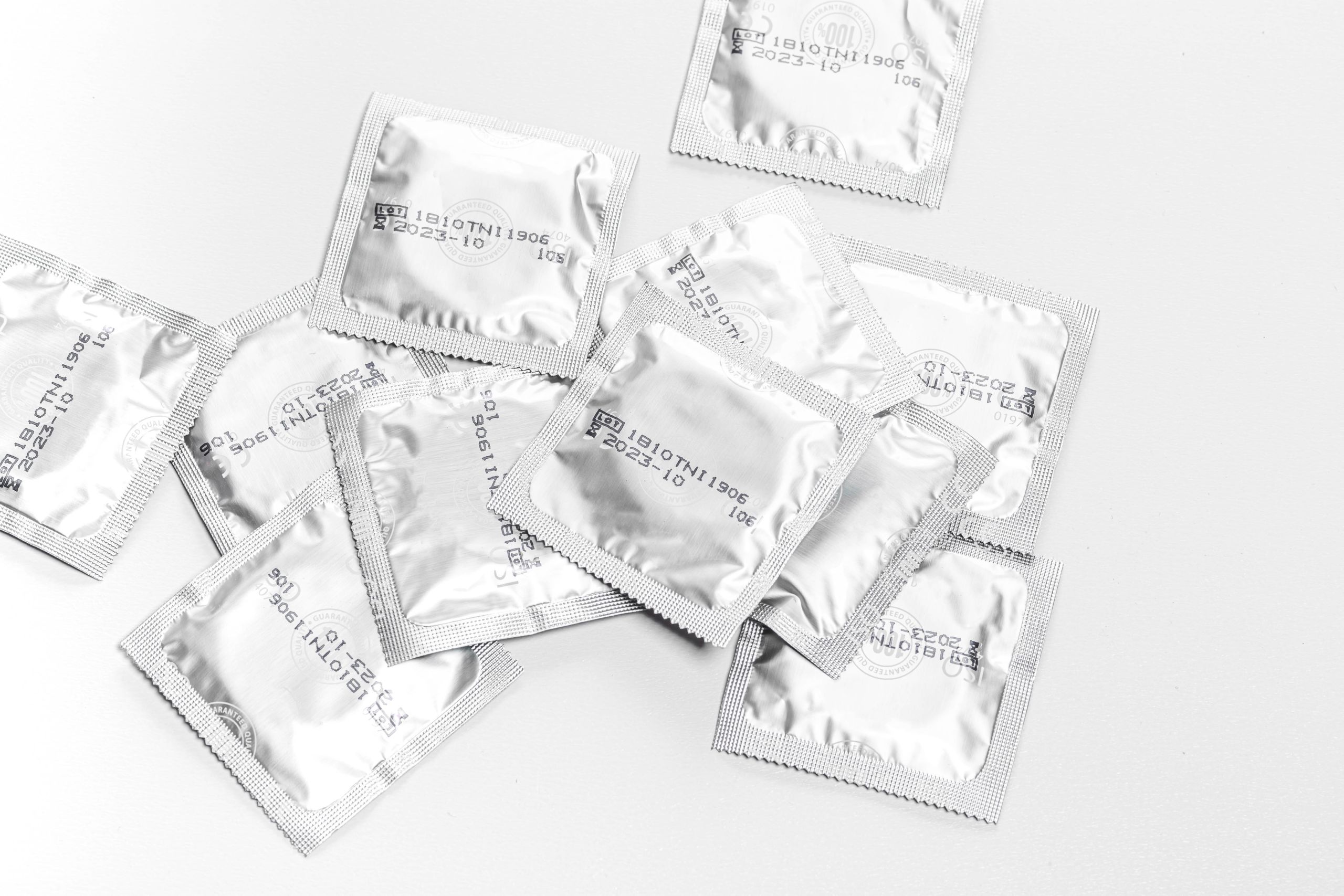 Sealed condoms on a white background.