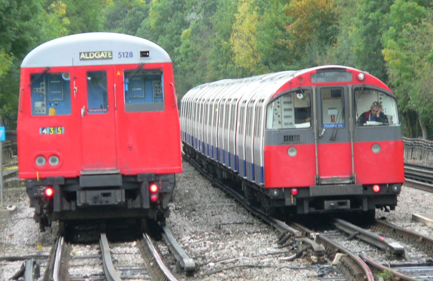 A sub-surface London train next to a deep tube train