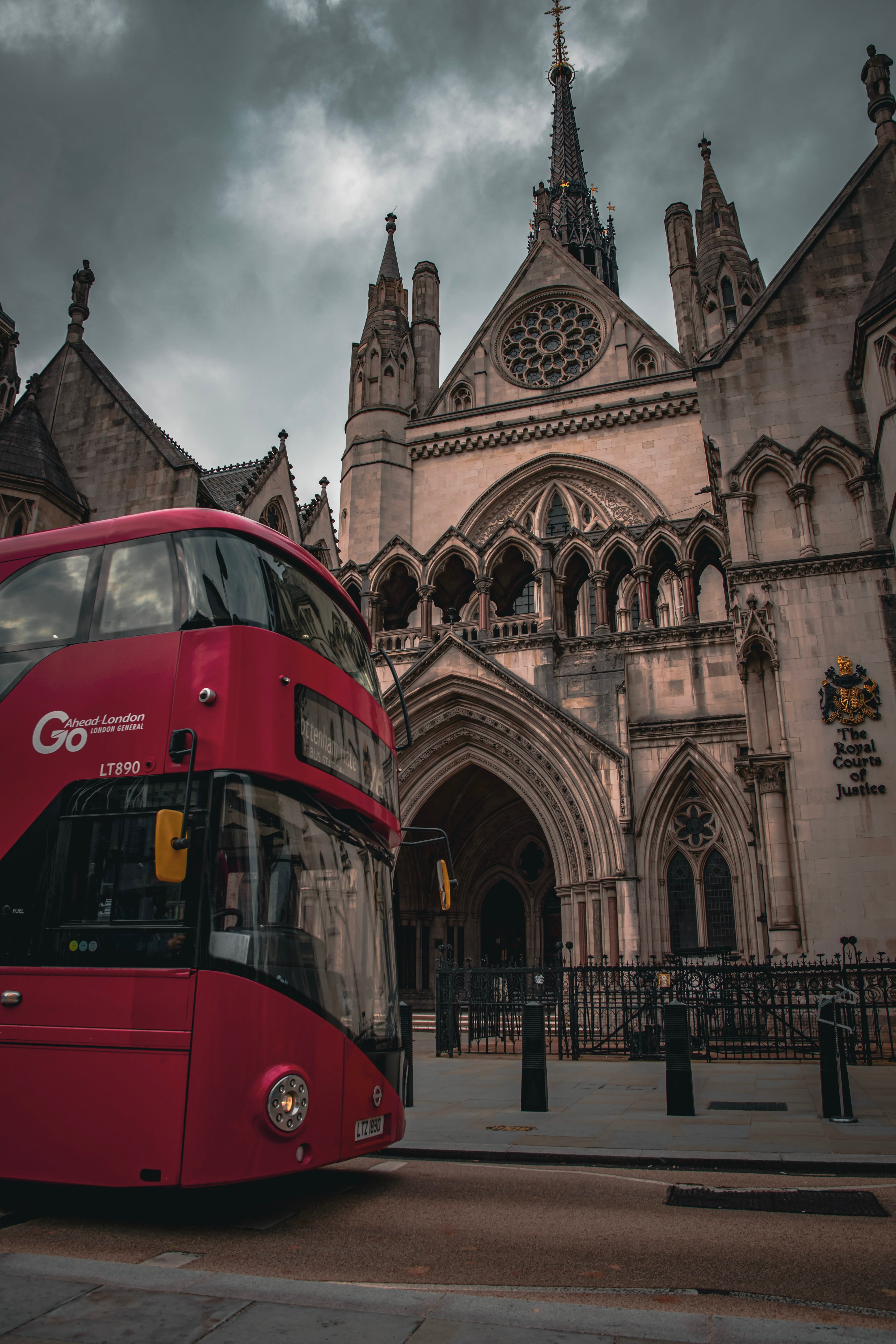 a red double decker bus in front of a large building