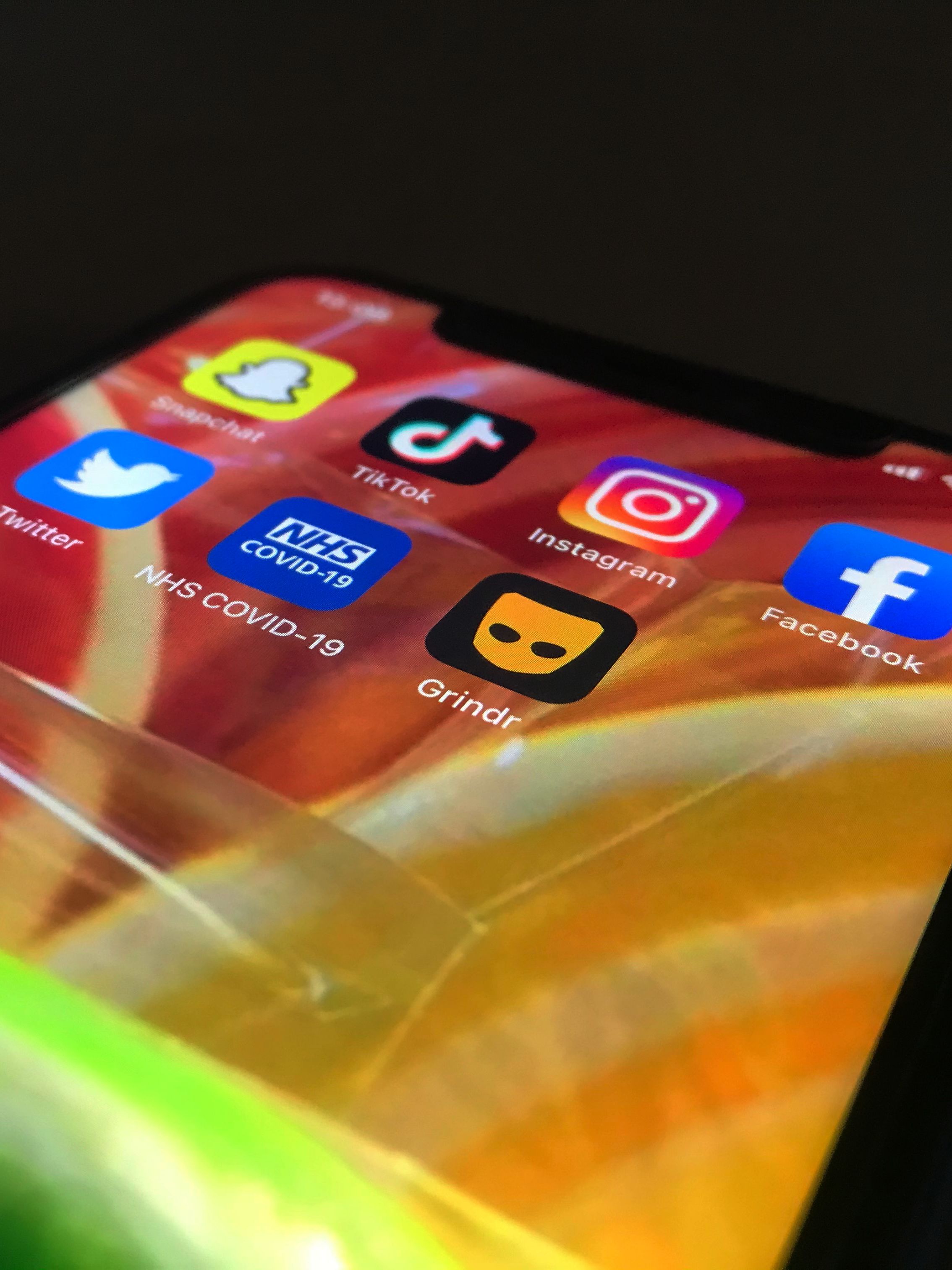 A phone showing a range of social media apps, the NHS Covid-19 app, and Grindr