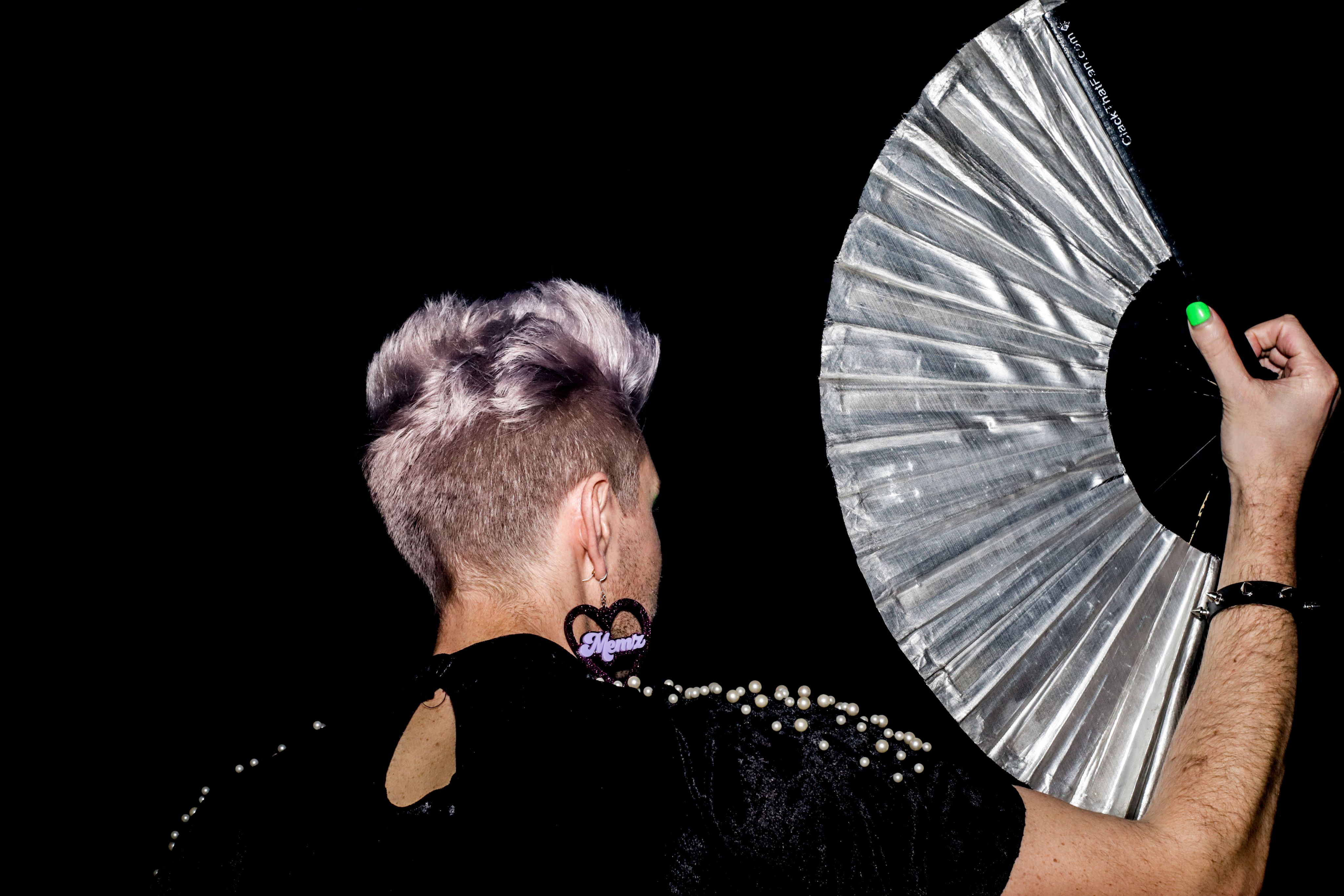 Dance with purple hair holds giant silver fan