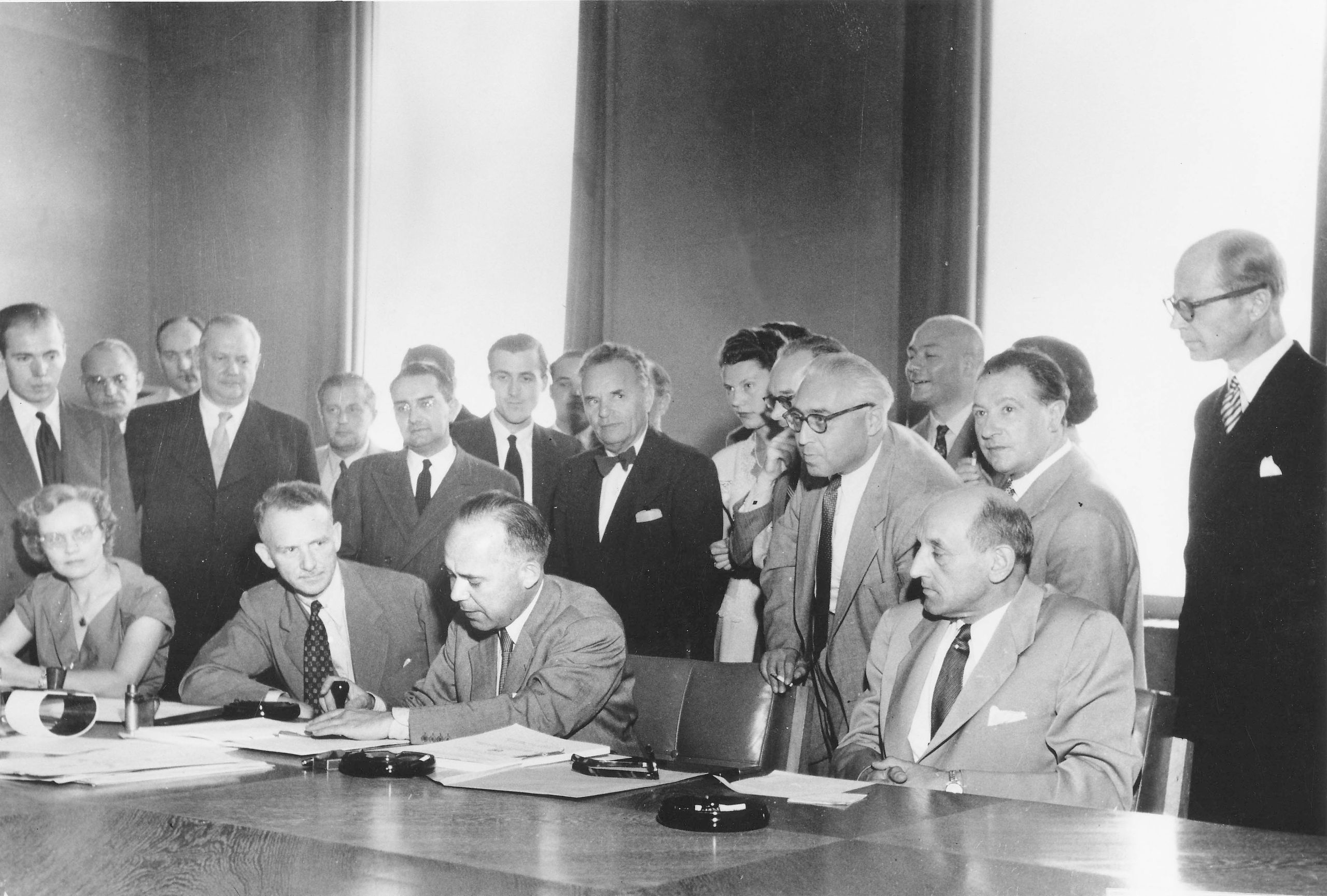 © UNHCR. Signature of the 1951 Refugee Convention in Geneva, Switzerland / the three seated men (l-r): Mr. John Humphrey, Director of the Human Rights Division; Mr. Knud Larsen (Denmark) President of the Conference; Dr. G.V. van Heuven Goedhart, High Commissioner for Refugees / copyright Arni / UN Archives / August 1, 1951.