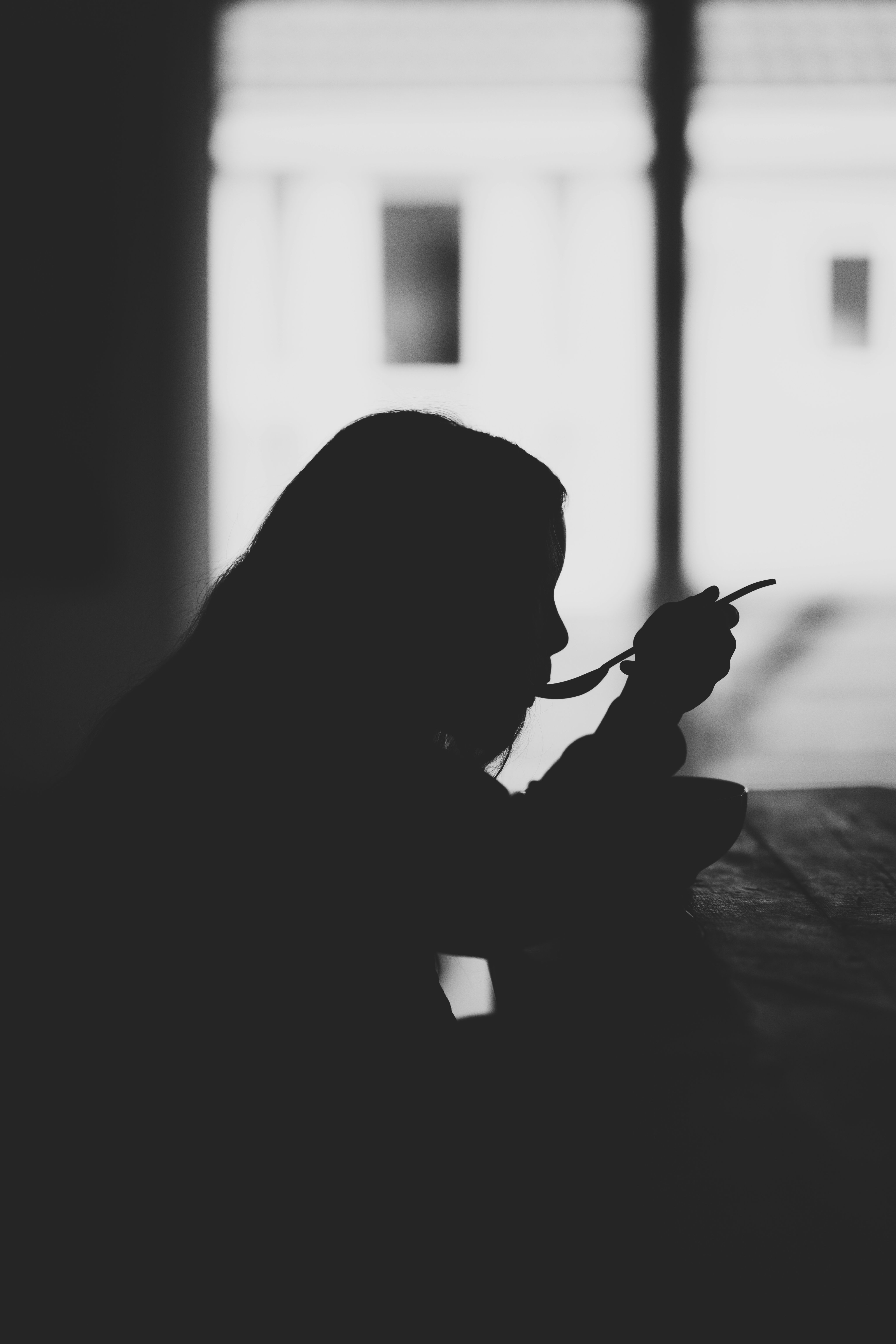 Black and white picture of girl eating off spoon
