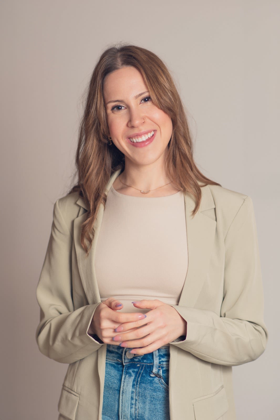 Ciandra Birnbaum smiling with hands clasped