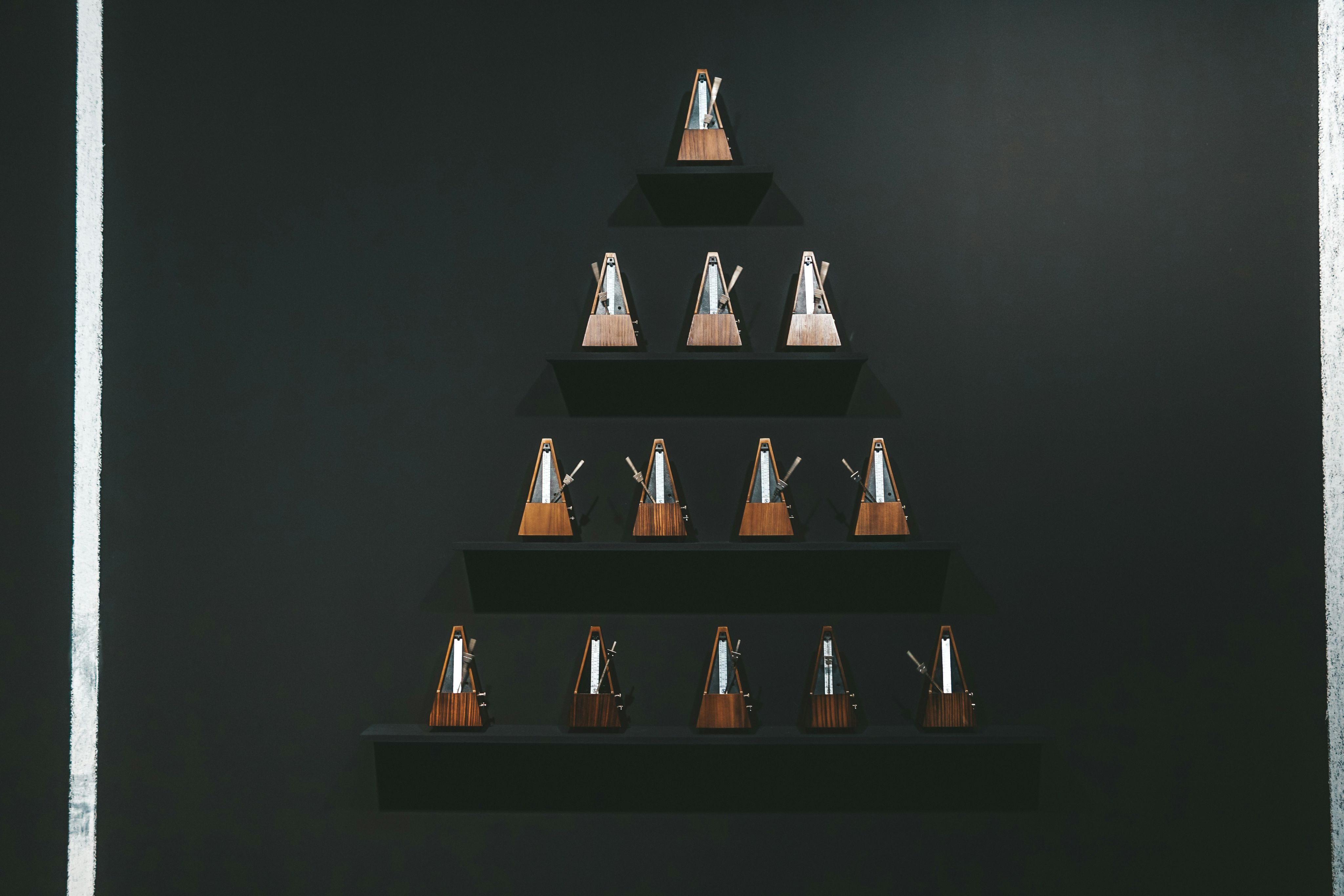 a black wall with a wooden shelf with a christmas tree on it