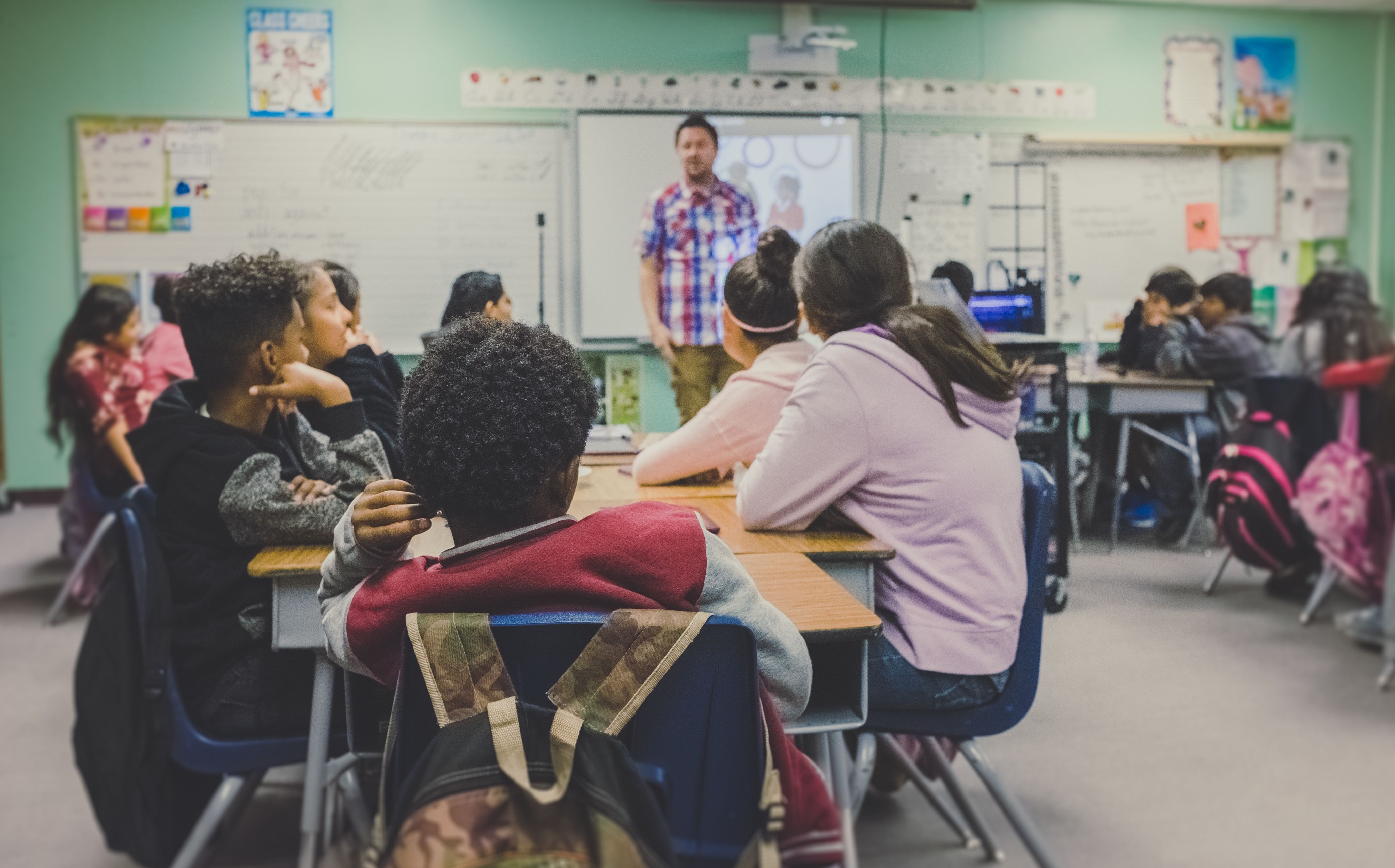 Teacher stands in front of the class and teaches a lesson