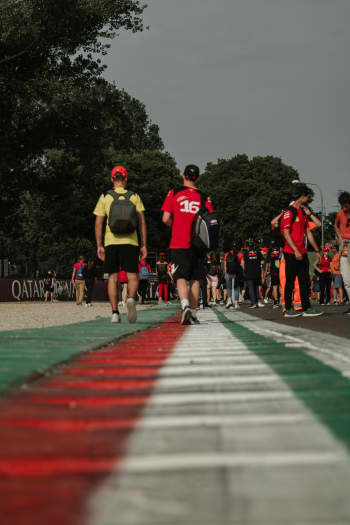 A group of people walking down a race track