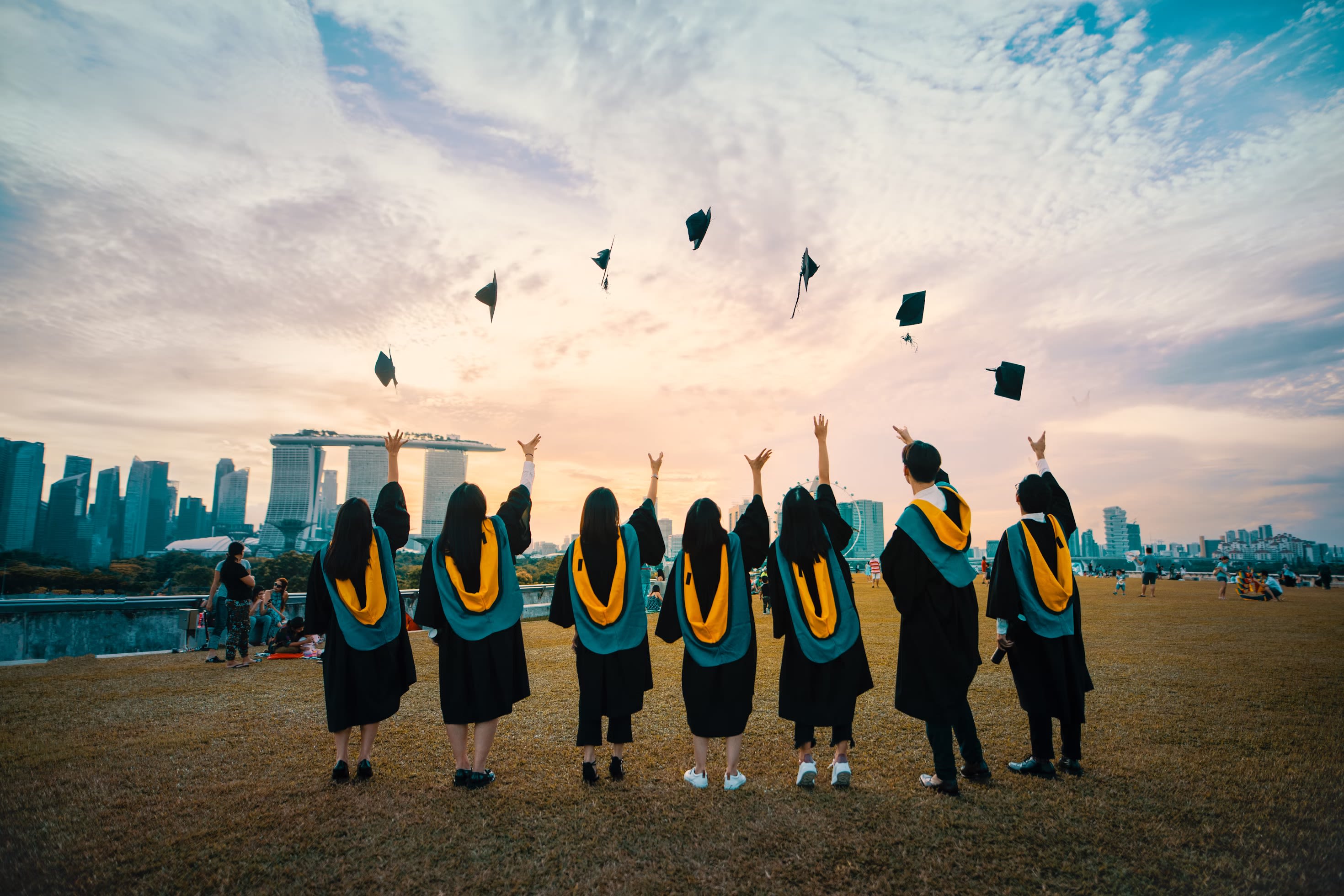 Group of students throwing graduate caps in the air 