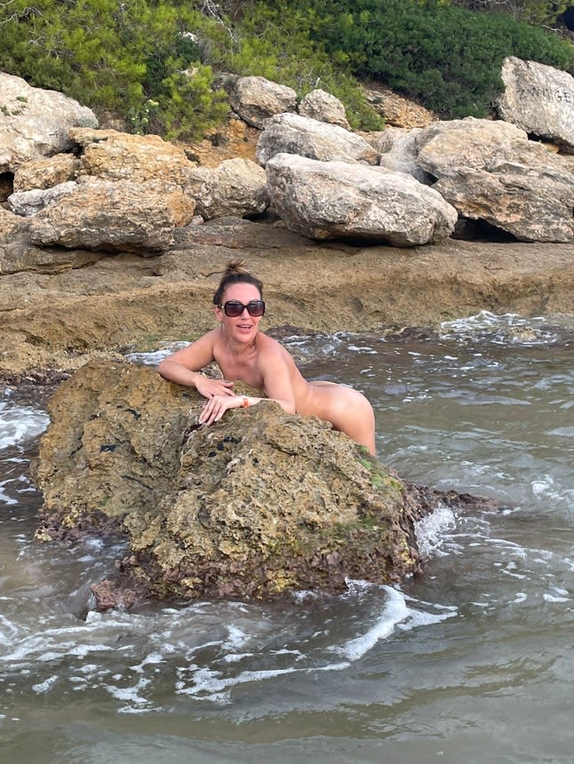 naked woman on a rock in the sea