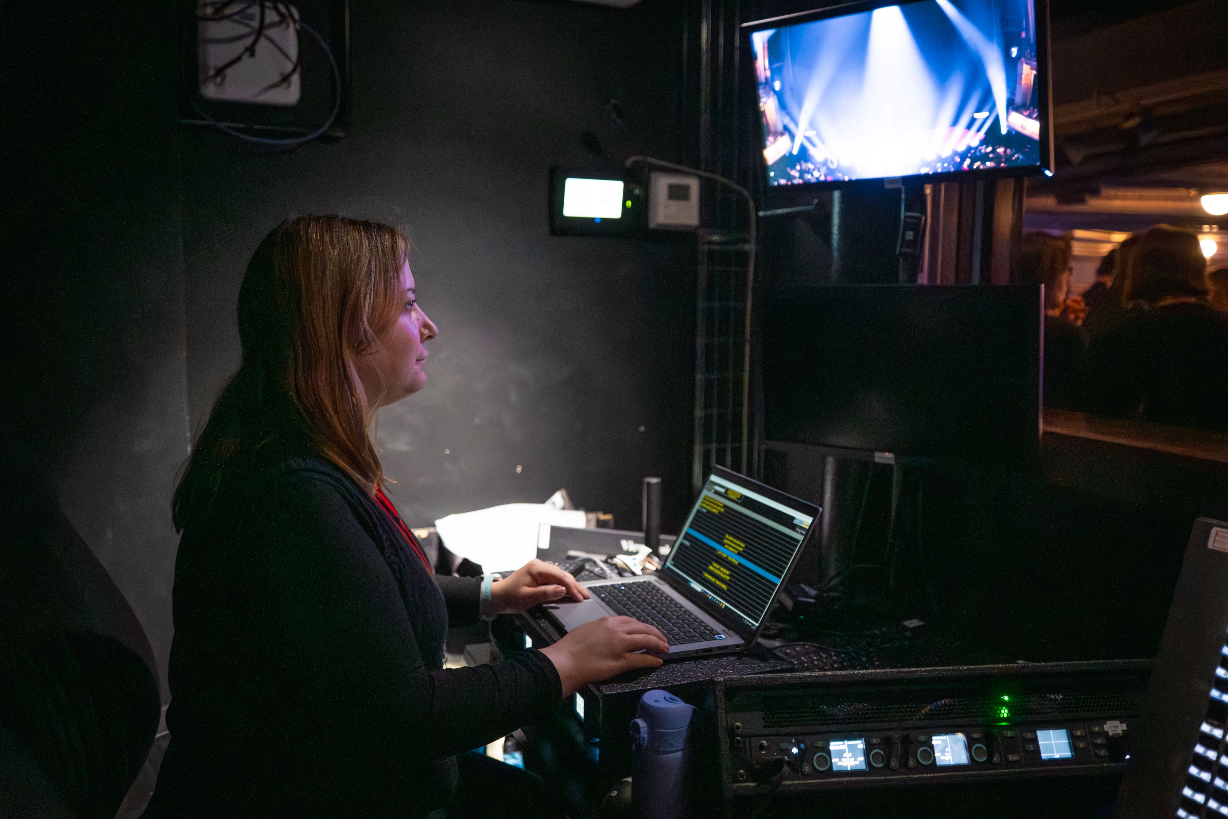 Captioner Alex Romeo watches the action unfold on stage