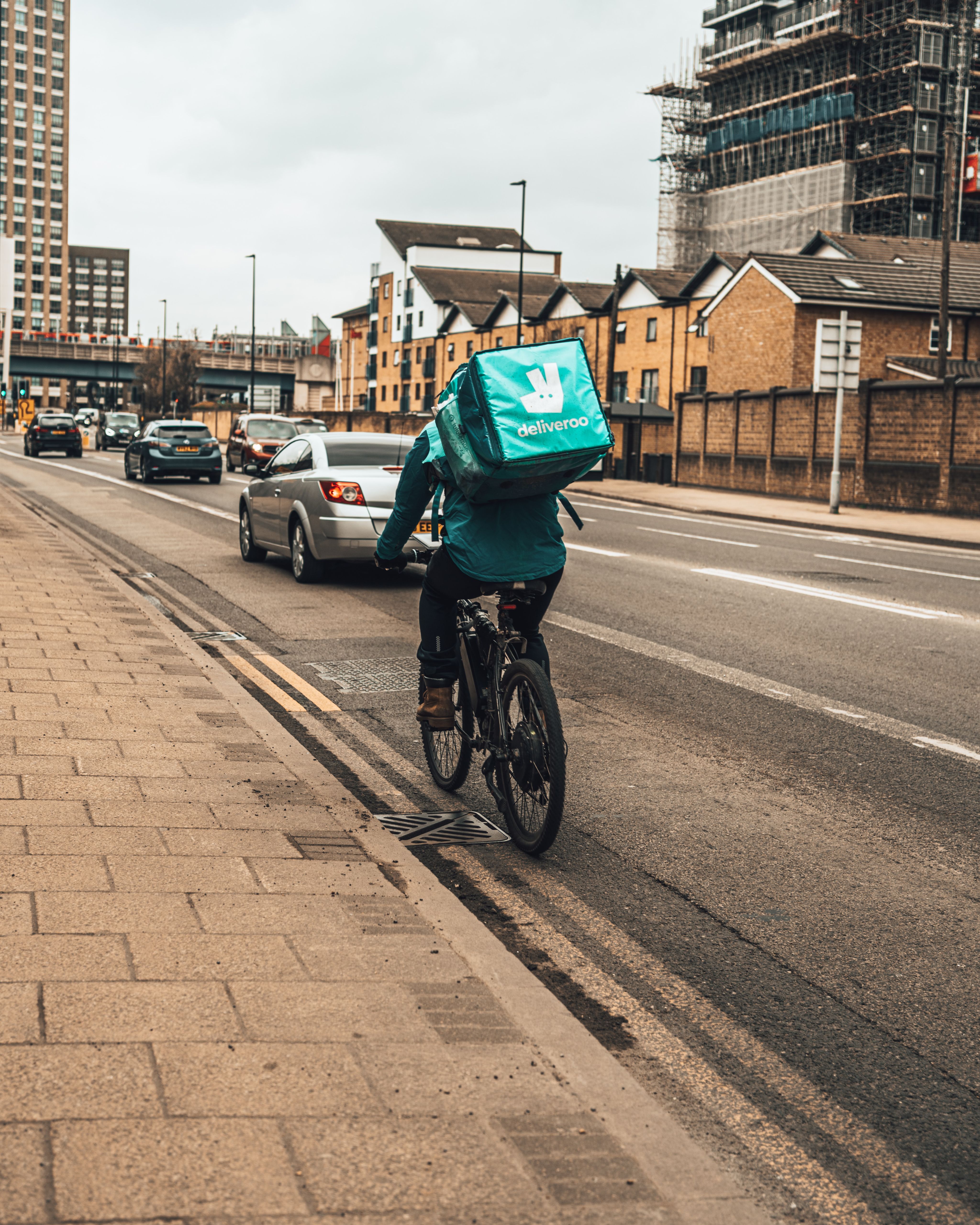 Deliveroo riders riding down a street