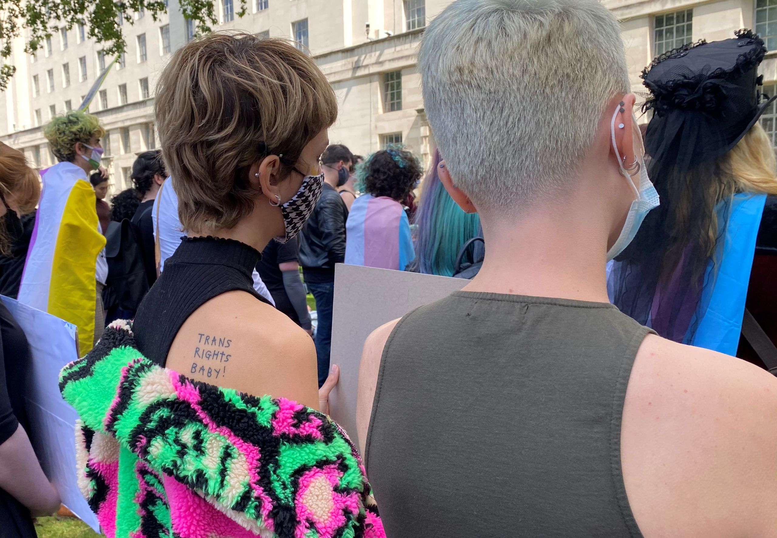 A protester with a tattoo reading "Trans rights baby!"