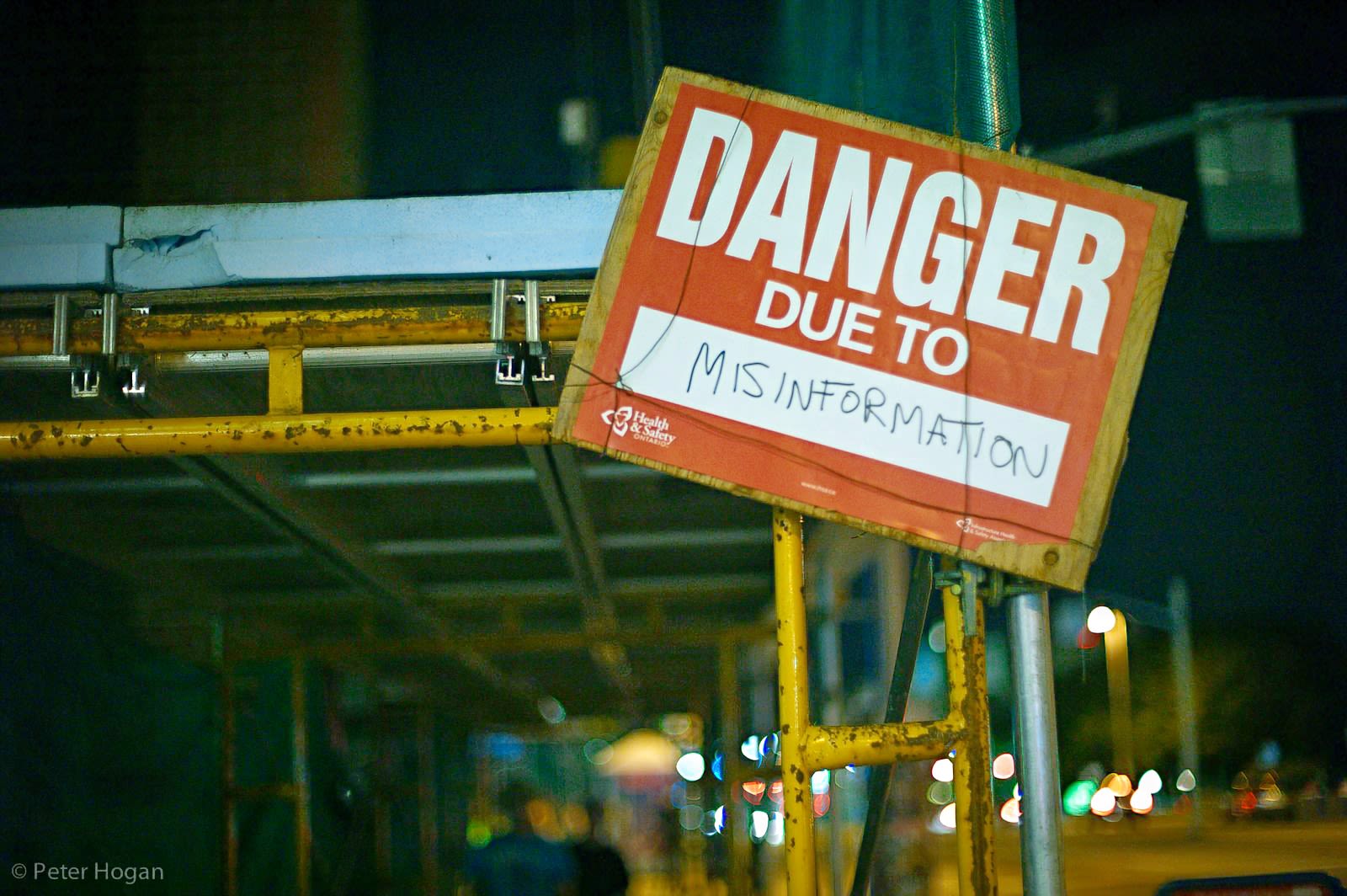 a dirty red sign saying 'Danger Due to Misinformation'